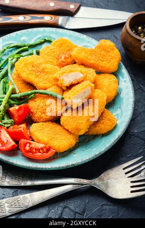 Köstliche gebratene Hähnchennuggets mit Kuhpfeiben auf dem Teller Stockfoto