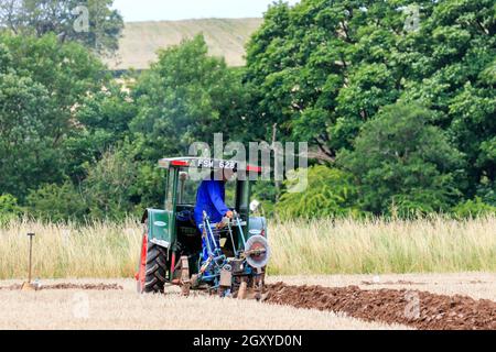 Middleshaw, Schottland - 16. August 2020 : Vintage Fordson Traktor pflügt mit einem Vintage gezogenen Ransomes Pflug Stockfoto