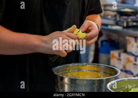 Kochen Sie das Schneiden von Kartoffeln in kleine Stücke, um die typische spanische Mahlzeit, Tortilla de Patatas, zuzubereiten. (Kartoffelomelett) Stockfoto