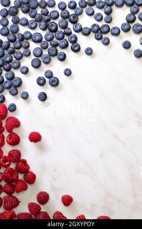 Stillleben mit Heidelbeeren, Erdbeeren und Himbeeren auf weiß gemustertem Hintergrund Stockfoto