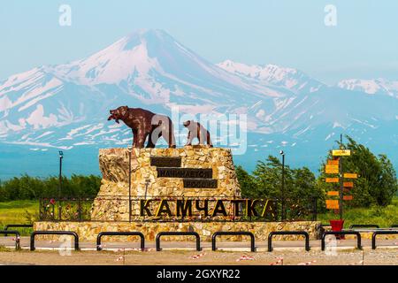 Yelizovo, Russland - 17. Juli 2018: Denkmal, das sie mit dem Jungen auf dem Hintergrund des Avatschinski-Vulkans trägt. Stockfoto