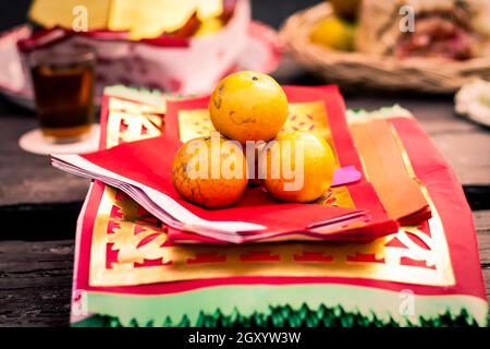 Orangefarbene Früchte auf traditionellem chinesischen Papier zum Beten des chinesischen Neujahrs Stockfoto