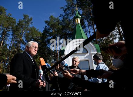Korjukiwka, Ukraine. Oktober 2021. Bundespräsident Frank-Walter Steinmeier (l.) spricht vor den Medien an der Grabstätte für die Opfer der deutschen Massaker. In Korjukiwka gedenkt Steinmeier der größten sogenannten "Strafmaßnahmen" der deutschen Besatzer gegen Zivilisten während des Zweiten Weltkriegs. Anfang März 1943 wurden dort unter einem speziellen SS-Kommando etwa 6,700 Menschen als Reaktion auf die sowjetische Partisanenbewegung ermordet. Kredit: Britta Pedersen/dpa-Zentralbild/dpa/Alamy Live Nachrichten Stockfoto