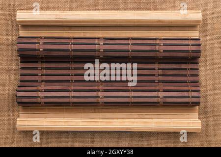 Hell und Dunkel Bambus Matte in der Form von Blättern liegen auf der Leinwand. Ansicht von oben Stockfoto