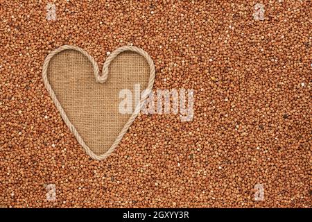 Symbolische Herz des Seils liegt auf Sackleinen und Buchweizen Körner, mit Platz für Ihren text Stockfoto