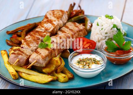 griechische Souvlaki-Spieße mit pommes frites Stockfoto