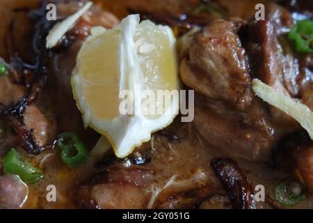 Nahaufnahme des traditionellen pakistanischen Haleem-Gerichts mit Salat und Zitronensaft. Stockfoto