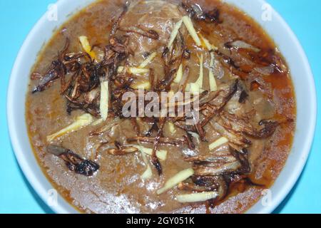 Nahaufnahme des traditionellen pakistanischen Haleem-Gerichts mit Salat und Zitronensaft. Stockfoto