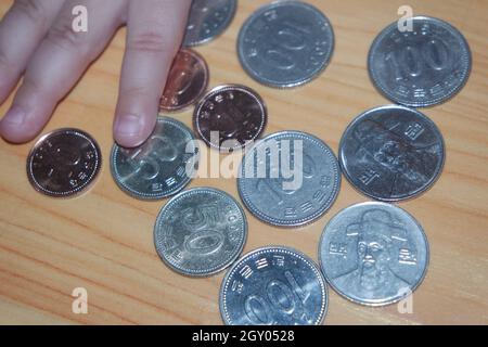 Silber glänzenden koreanischen gewann Münze über einem Holzboden verstreut. Stockfoto