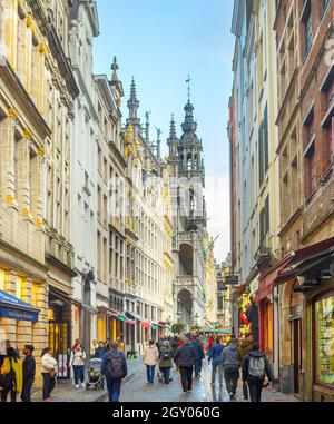 BRÜSSEL, BELGIEN - 06. OKTOBER 2019: Menschenmenge, die durch die Altstadt-Einkaufsstraße von Brüssel läuft, Grand Place im Hintergrund Stockfoto