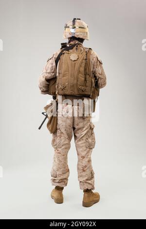 Soldat in US-Marines Uniform mit Gewehr auf hellgrauem Hintergrund, Studioschuss Stockfoto