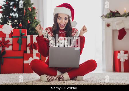 Ganzkörper-Foto von glücklich erstaunt schockiert junge Frau schauen Laptop Gewinner weihnachten drinnen Haus Stockfoto