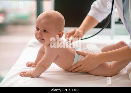 Säugling, der mit einem sterilen Stethoskop auskultiert wird Stockfoto