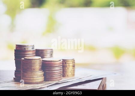 Euro-Münzen übereinander gestapelt in verschiedenen Positionen. Münzen und Dollar-Konzept. Münzstapel auf einem Backstein-Hintergrund Stockfoto