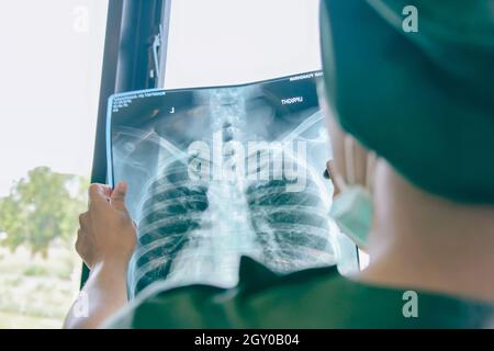 Arzt, der den Röntgenfilm des Patienten in der Stationsklinik untersucht. Stockfoto