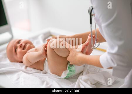 Neugeborenes Kind, das in einer Klinik einer körperlichen Untersuchung unterzogen wird Stockfoto