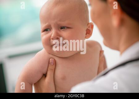 Verängstigte Neugeborene, die während einer medizinischen Untersuchung wegschauen Stockfoto