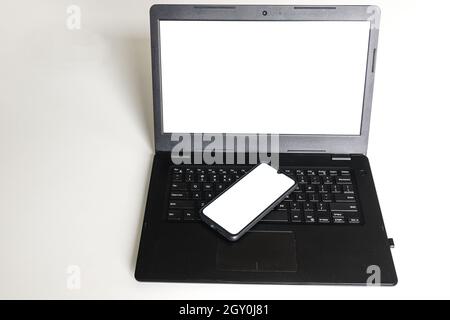 Leeres Smartphone und Laptop mit weißem Bildschirm für Mockup. Handy- und PC-Modell Stockfoto