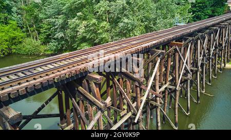 Eisenbahn alte Holzbrücke über den Fluss von der Luftseite Stockfoto