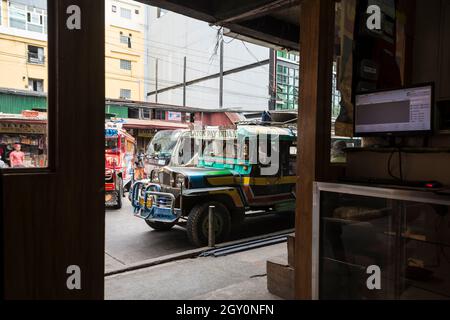 Blick von einem Geschäft auf einer Straße mit vorbeifahrenden Jeepneys in Baguio, Philippinen Stockfoto