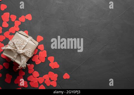 Grußkarte zum Valentinstag. Box mit einem Geschenk auf einem Stein Hintergrund. Rote Herzen. Speicherplatz kopieren. Blick von oben. Stockfoto