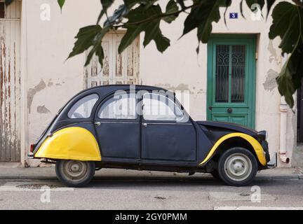 Oldtimer-Wagen des Autos, schwarz und gelb, geparkt auf der Straße vor dem Haus auf der Straße im Dorf in Frankreich Stockfoto