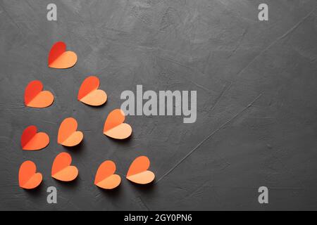 Alles Liebe zum Valentinstag. Hearts aus rotem Papier auf dunklem Betongrund. Valentinstag-Konzept. Baner. Stockfoto