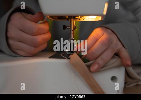 Nähprozess, Nahaufnahme der weiblichen Hände in der Nähe der Nadel einer Nähmaschine. Stockfoto