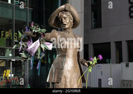 Emmeline Pankhurst Statue, Manchester UK, mit schottischem Kranz auf einer Hand. Schartanfarbene und violette Farbtöne. Petersplatz Stockfoto