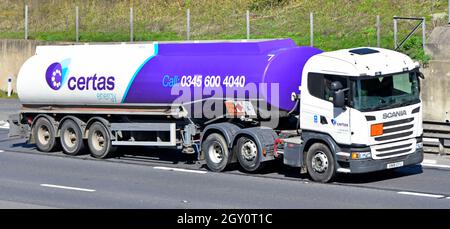 Seiten- und Vorderansicht des weißen lkw-LKW-LKW Scania und des purpurnen Tanklastwagens, der von certas Energy Business auf der britischen Autobahn betrieben wird Stockfoto