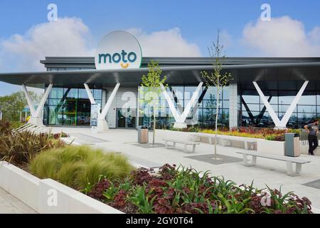 Sitzgelegenheiten im Freien in der Gartenanlage & Blumenbepflanzung im modernen Design der neuen Moto-Tankstelle an der Autobahn M6 Rugby Junction Warwickshire England Großbritannien Stockfoto