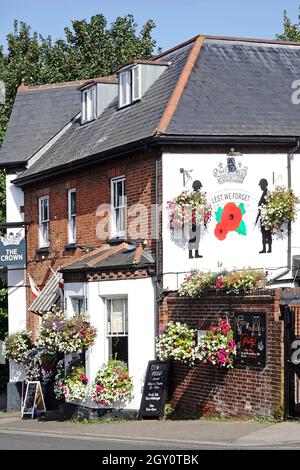 Sommer hängen Korb Blume zeigt im Crown öffentlichen Haus mit einem Lest We Forget Mohn & Soldaten Wandgemälde auf High Street Billericay UK gemalt Stockfoto