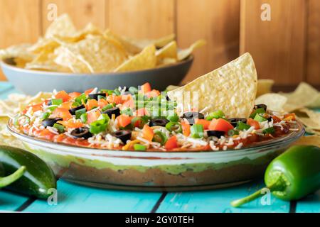 Nahaufnahme eines mexikanischen Dips mit einer Schüssel Nacho-Chips im Hintergrund. Stockfoto