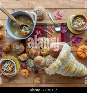 Von oben aus hat man einen Blick auf das Brotcornucopia, gefüllt mit frischen Brötchen, umgeben von hausgemachter putensuppe. Stockfoto