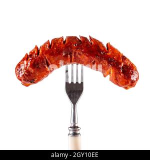 Geröstete geräucherte Wurst auf Gabel isoliert auf weißem Hintergrund. Stockfoto