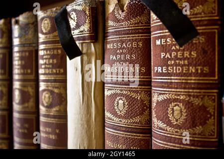 Alte Bücher, die mit Stoff gebunden sind, standen auf einem Regal Stockfoto