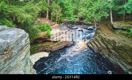 Blick in die lebhafte Schlucht mit Wasserfällen und Flechten bedeckten Felsen im Wald Stockfoto