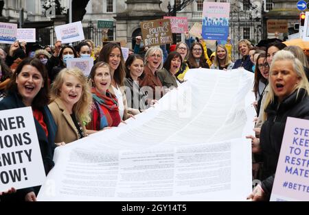 Eine Schriftrolle mit Hunderten von Geschichten über die Erfahrungen von Menschen, die während der Covid 19 schwanger waren und gebären, wird von Politikern und Mitgliedern der Kampagne #BetterMaternityCare während eines marsches im Leinster House, Dublin, gehalten. Forderung nach einem Ende der anhaltenden Beschränkungen in einigen Entbindungskliniken für den Zugang von Geburtspartnern. Bilddatum: Mittwoch, 6. Oktober 2021. Stockfoto