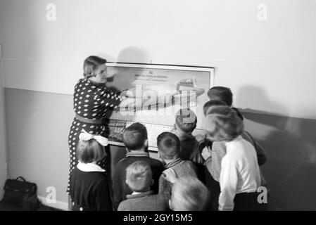 Eine Schulklasse lässt sich mit großem Interesse von ihrer Lehrerin den Aufbau eines Zeppeline erklären, Zeppelin Siedlung bei Frankfurt am Main, Deutschland 1930er. Ein Lehrer erklärt den Bau einer zeppelinl zu ihrer Schüler, die Hören mit großem Interesse sind, zeppelin Dorf in der Nähe von Frankfurt am Main, Deutschland 1930. Stockfoto