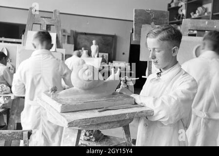 Ein Schüler der Fachschule für Keramik beim Gestalten einer Schnecke in den Arbeitsateliers, Höhr-Grenzhausen, Deutschland 1930er Jahre. Ein Student der Hochschule für Keramik arbeiten auf eine Schnecke in den Ateliers, Höhr-Grenzhausen, Deutschland 1930. Stockfoto