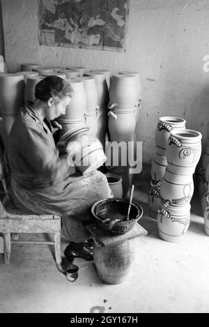 Eine Töpfermeisterin aus dem Kannenbäckerland bemalt Steinkrüge in der charakteristischen blauen Glasur des Westerwälder Steinguts, Deutschland 1930er Jahre. Ein Master Potter Malerei steinzeug Krüge in der typischen blauen Farbe der Westerwälder Steinzeug, Deutschland 1930. Stockfoto