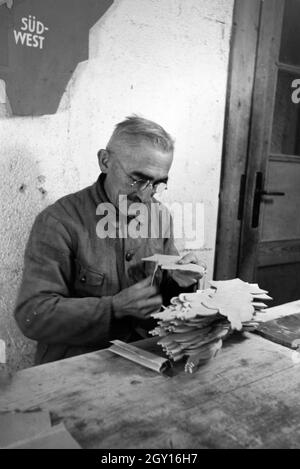 Ein Mitarbeiter in der Höhle Heller / Werkstätten in der Eifel schleift die Kanten der ausgesägten Holzfiguren ab, Deutschland 1930er Jahre. Ein Mitarbeiter der Heller / Workshops in der Eifel Schleifen der Kanten der Ausgesägt Holzfiguren, Deutschland 1930. Stockfoto