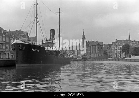 Das Schiff "Borkum" im Hafen von Emden mit Blick in das Emder Rathaus, Deutschland 1930er Jahre. Schiff "Borkum" im Emder Hafen mit Blick auf die Stadt und die Stadt Halle, Deutschland 1930. Stockfoto