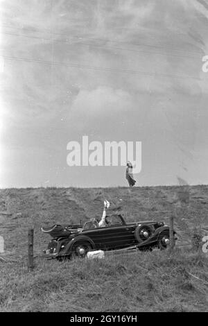 Unterwegs in einem Audi Cabrio bei Norddeich, Deutschland 1930er Jahre. Menschen in einem Audi Cabrio in der Nähe von Norddeich, Deutschland 1930. Stockfoto