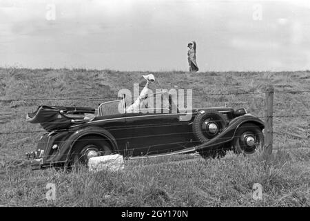 Unterwegs in einem Audi Cabrio bei Norddeich, Deutschland 1930er Jahre. Menschen in einem Audi Cabrio in der Nähe von Norddeich, Deutschland 1930. Stockfoto