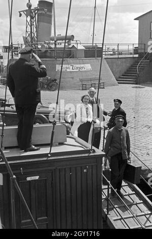 Fahrgäste werden vom Classic-car salutierend begrüßt an der Mole in Norddeich, Deutschland 1930er Jahre. Die Passagiere werden Grüßte durch den Kapitän an der Pier in Norddeich, Deutschland 1930. Stockfoto