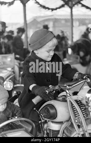 Ein kleiner Junge mit dem Weihnachtsmarkt, Deutsches Reich 30er Jahre. Ein kleiner Junge auf dem Weihnachtsmarkt, Deutschland 1930. Stockfoto