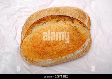 Sauerteig Brot auf weißem Seidenpapier Hintergrund Stockfoto