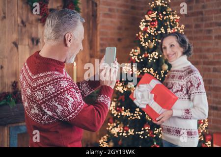 Foto Portrait älteres Paar fotografiert zusammen mit weihnachtsgeschenken lächelnd Stockfoto