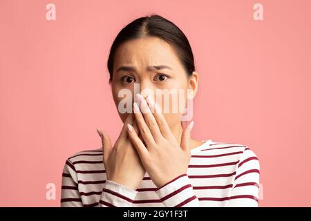 Oh Nein. Porträt Einer Schockierten Asiatischen Frau, Die Den Mund Mit Händen Bedeckt Stockfoto